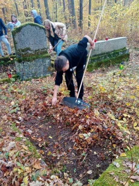 uczniowie klasy 8 sprzątają cmentarz